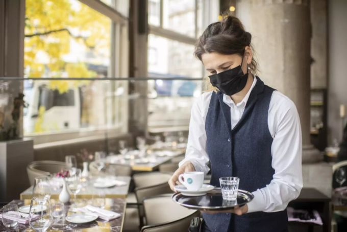 Eine Frau mit Atemschutzmaske serviert einen Espresso im Restaurant Terrasse, aufgenommen am Dienstag, 27. Oktober 2020 in Zürich. Gastgewerbe Restaurant Coronavirus