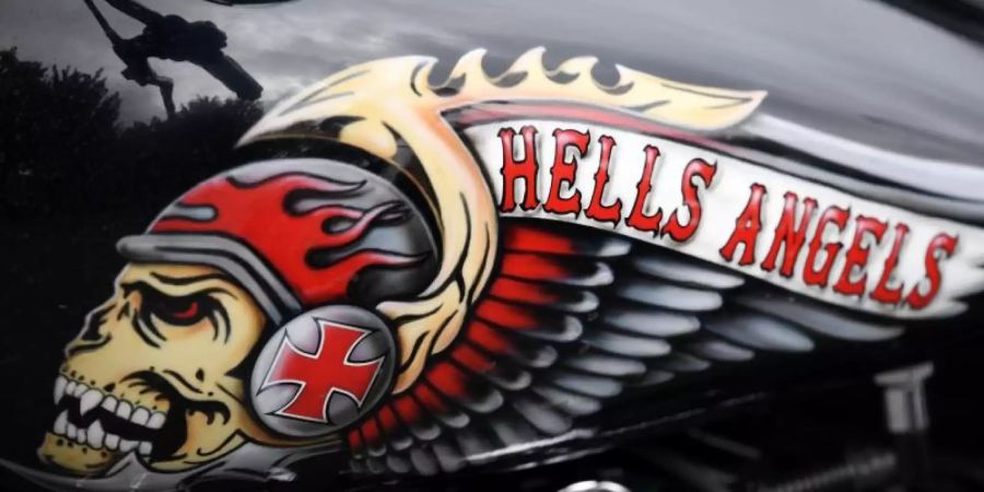 Das Hells Angels-Emblem, ein Totenkopf mit Helm und Flügeln, auf einem Tank eines abgestellten Motorrads. Foto: picture alliance / Arne Dedert/dpa