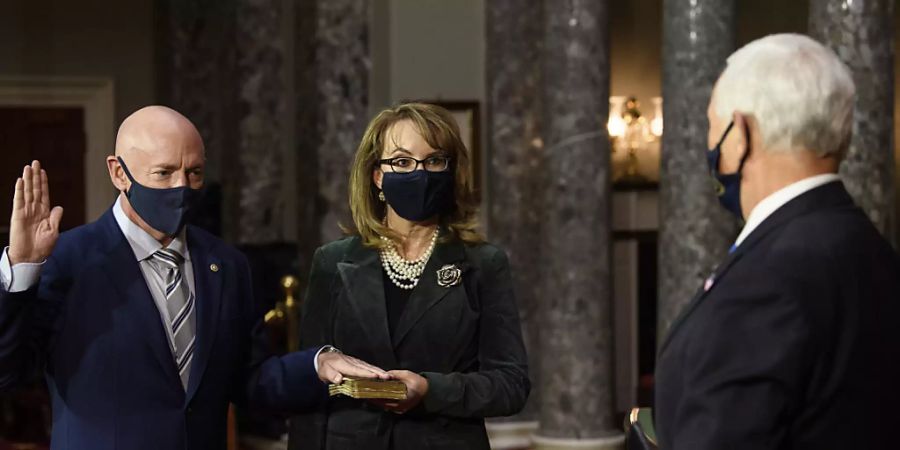 Der demokratische Senator Mark Kelly (l), Arizona, und seine Frau, die ehemalige Abgeordnete Gabby Giffords, nehmen  an einer Nachstellung seiner Vereidigung durch Vizepräsident Mike Pence in der alten Senatskammer auf dem Capitol Hill in Washington teil. Foto: Nicholas Kamm/POOL AFP/dpa