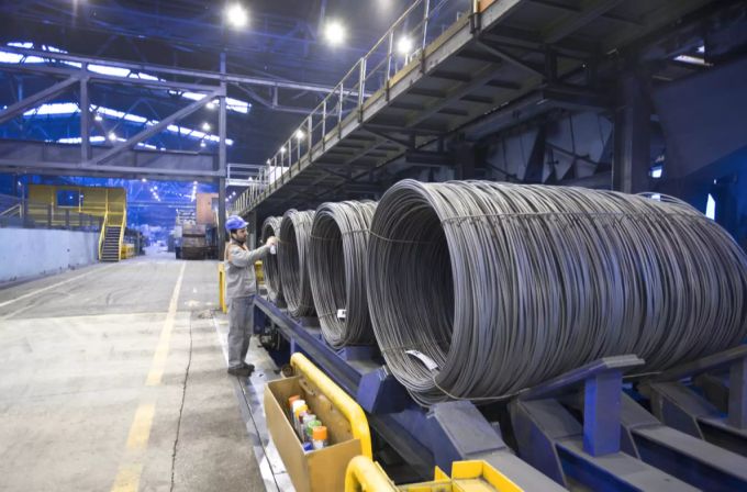 Ein Arbeiter besprüht Stahlrollen. (Symbolbild) Swiss Steel Stahl