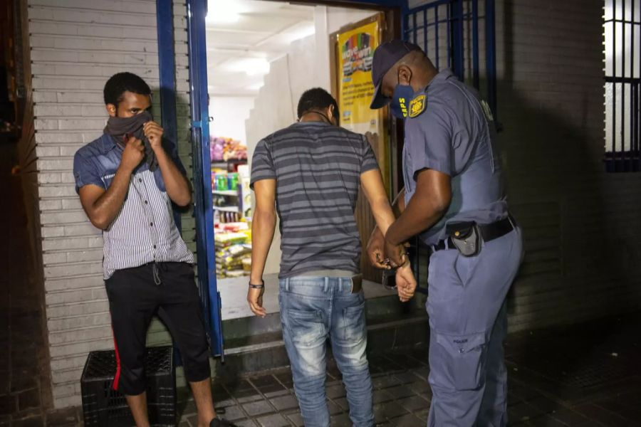 Ein Mann wird von der Polizei verhaftet, weil der die Lockdown-Regeln gebrochen hat, am 31. Dezember 2020  in Hillbrow/Johannesburg.