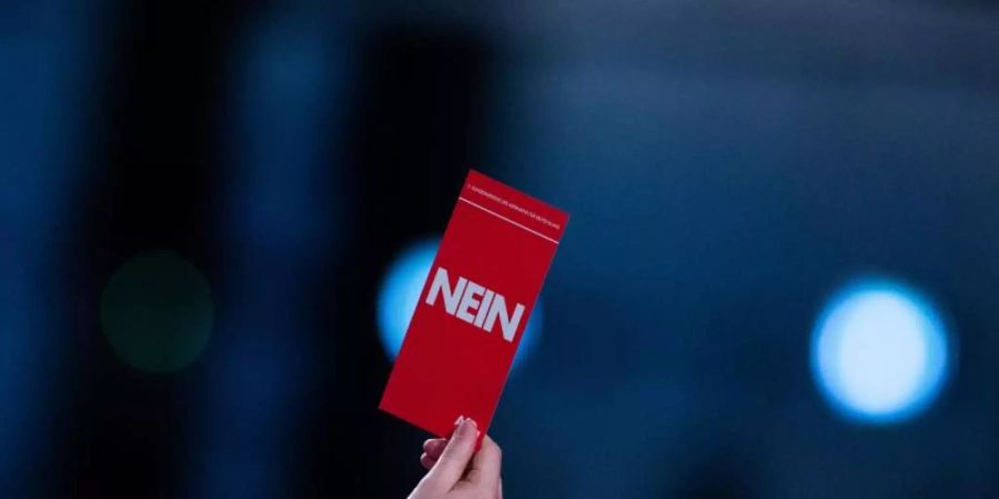 Einige Delegierte heben ihren Stimmzettel mit der Aufschrift "Nein" nach der Rede von Jörg Meuthen beim Bundesparteitag der AfD. Foto: Rolf Vennenbernd/dpa