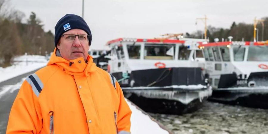 Andreas Schultz, Schiffsführer vom Eisbrecher „Elbe“, steht vor den beiden Eisbrechern „Elbe“ und „Biber“ in Scharnebeck. Foto: Philipp Schulze/dpa