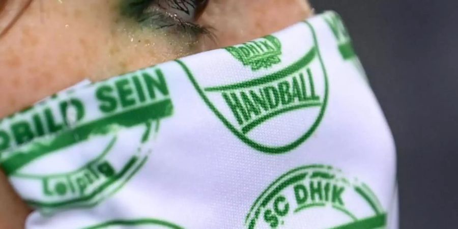 Mittlerweile neun Coronavirus-Fälle wurden beim SC DHfK Leipzig verzeichnet. Eine Cheerleaderin trägt einen Mund-Nasen-Schutz des Vereins. Foto: Hendrik Schmidt/dpa-Zentralbild/dpa