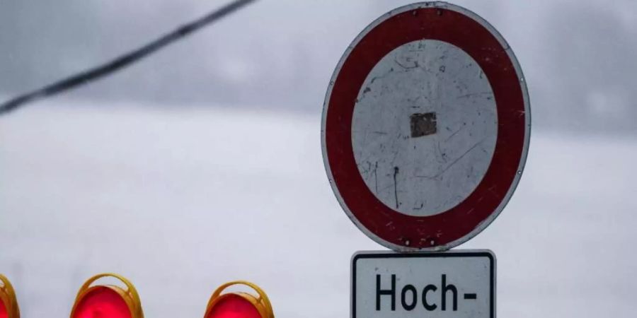 Ein Hochwasserschild steht am Rhein bei Mainz. Starkregen und Tauwetter sorgen aktuell in Rheinland-Pfalz für stark ansteigende Wasserstände. Foto: Andreas Arnold/dpa