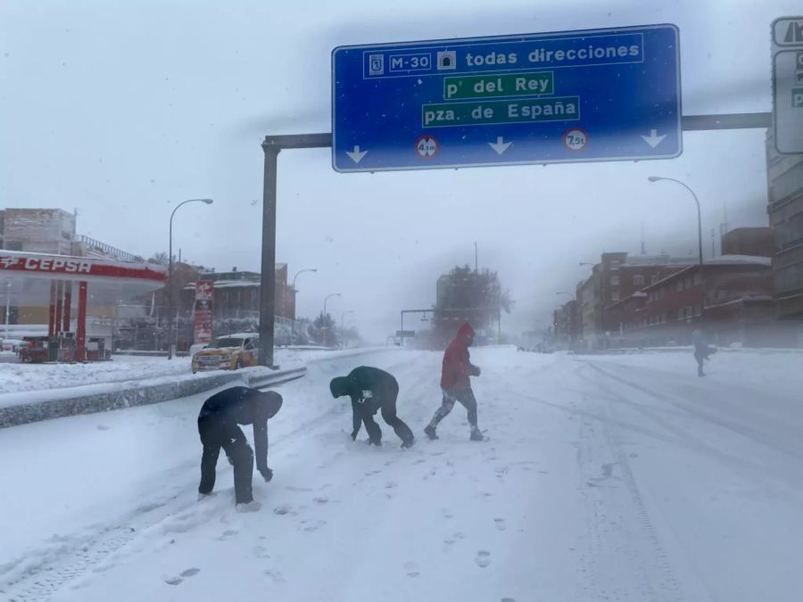 Passanten spielen im Schnee auf der M30 des Paseo de Extremadura.