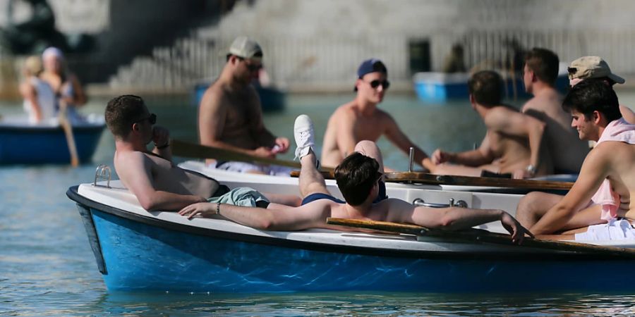 Touristen fahren mit einem Boot im Retiro-Park von Madrid. Teile Spaniens leiden schon im Mai unter einer verfrühten Hitzewelle. Am Freitagnachmittag stieg die Temperatur in der Stadt Andújar in Andalusien auf 41 Grad. Foto: Cézaro De Luca/EUROPA PRESS/dpa