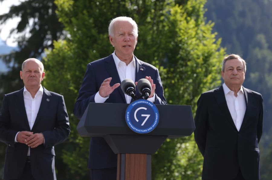 Ganz ernst und seriös: Joe Biden bei einer Rede beim G7-Gipfel, Olaf Scholz und Mario Draghi hören im Hintergrund zu.