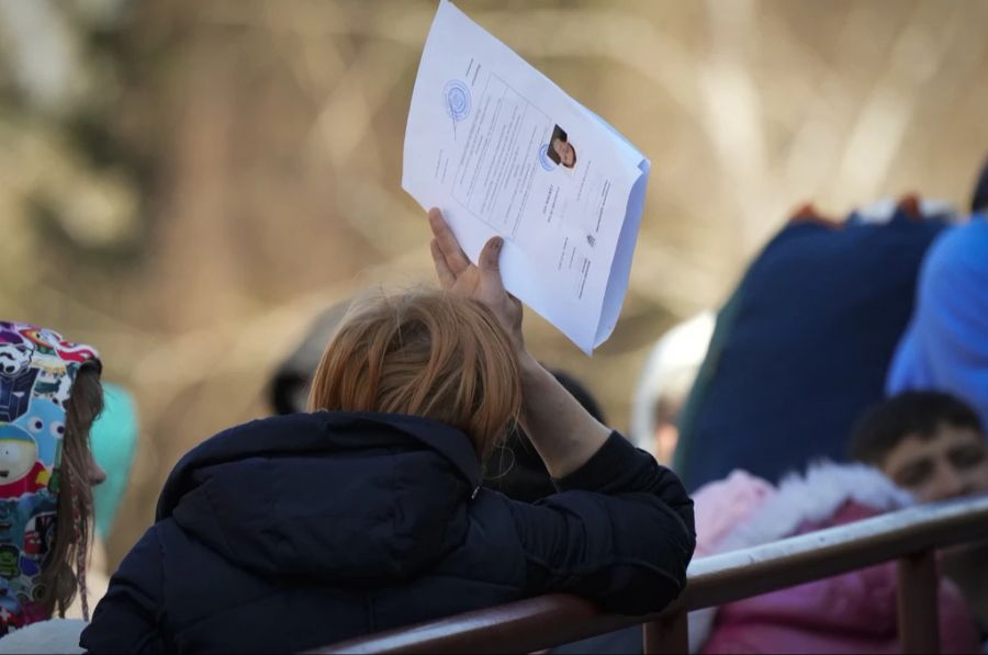 Eine Frau wartet mit ihren Dokumenten, um ihre Heimkehr anzutreten.