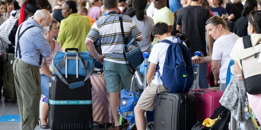Tausende Passagiere warten vor den Abfertigungsschaltern des Flughafens auf ihren Check-In.