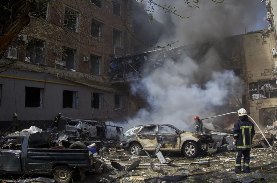 Ukrainische Feuerwehrleute arbeiten in einem beschädigten Wohngebiet nach einem russischen Beschuss in Charkiw am 16. April 2022.