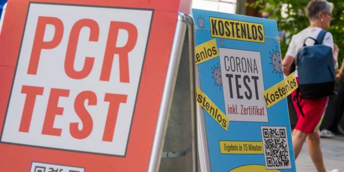 Schilder mit der Aufschrift «PCR Test» und «Corona-Test - Kostenlos» hängen vor dem Eingang einer Apotheke in der Innenstadt von München. Schilder mit der Aufschrift «PCR Test» und «Corona-Test - Kostenlos» hängen vor dem Eingang einer Apotheke in der Innenstadt von München.