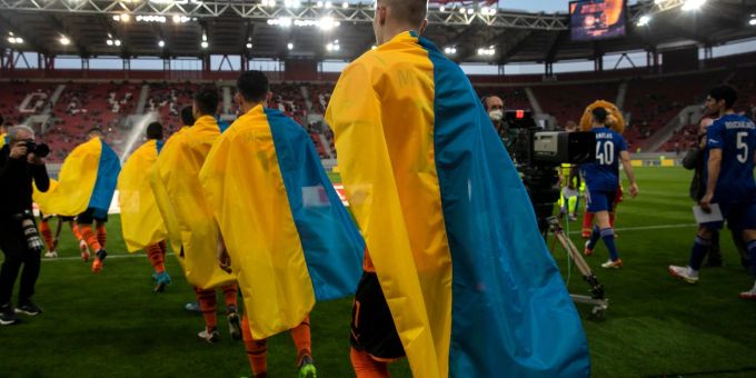 Schachtar-Spieler (l) betreten für ein Benefizspiel gegen Olympiakos Piräus den Rasen. Die Saison in der Ukraine ist abgebrochen worden. Ukraine Krieg