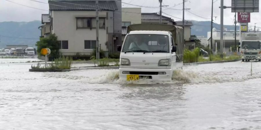 Eine Strasse in Tachiarai in der Präfektur Fukuoka im Südwesten Japans steht nach starken Regenfälle unter Wasser. Foto: Kyodo/dpa