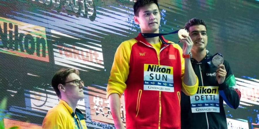 Silbermedaillengewinner Mack Horton (l) hält bei der Siegerehrung von Sun Yang demonstrativ Abstand von dem erstplazierten Chinesen (M). Foto: Bernd Thissen