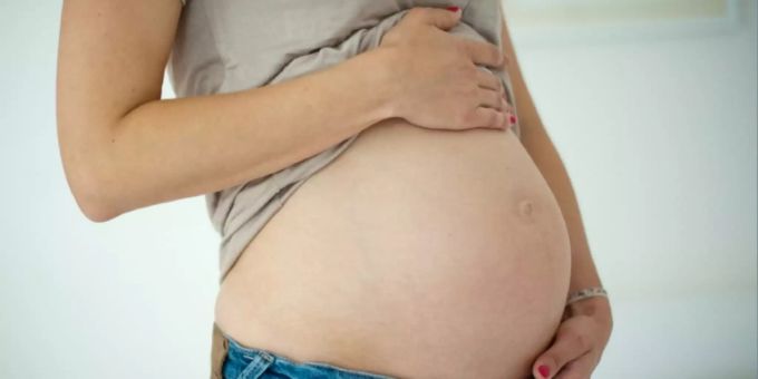 Eine Frau hält ihren Babybauch Eine Frau hält ihren Babybauch