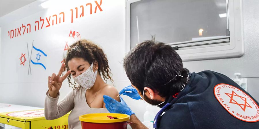 HANDOUT - Eine junge Frau wird in Israel in einem mobilen Impf-Bus geimpft. Foto: Kfir Sivan/Tel Aviv-Yafo Municipality/dpa - ACHTUNG: Nur zur redaktionellen Verwendung im Zusammenhang mit der aktuellen Berichterstattung und nur mit vollständiger Nennung des vorstehenden Credits