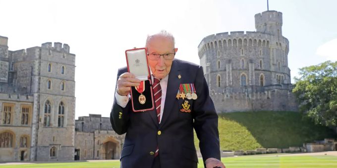 ARCHIV - 17.07.2020, Grossbritannien, Windsor: Sir Tom Moore, Weltkriegsveteran und Rekord-Spendensammler, zeigt nach seinem Ritterschlag durch die Queen am Schloss Windsor seine Medaille. Captain Tom nach Corona-Infektion gestorben