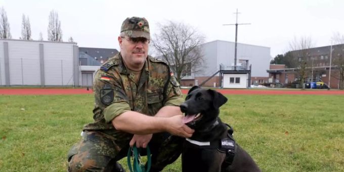 Hauptfeldwebel Alexander Schmidt von der Logistikschule der Bundeswehr in Garlstedt hat Therapiehund «Krümel» an der Leine. Foto: Marine Hauptfeldwebel Alexander Schmidt von der Logistikschule der Bundeswehr in Garlstedt hat Therapiehund «Krümel» an der Leine. Foto: Marine