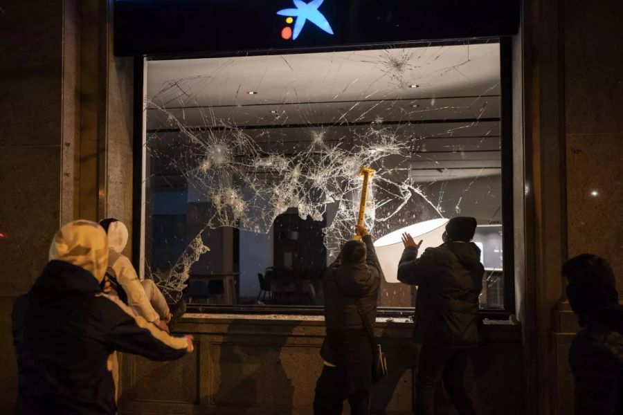 Demonstranten zerstörten etwa auch Fensterscheiben einer Bank in Barcelona.