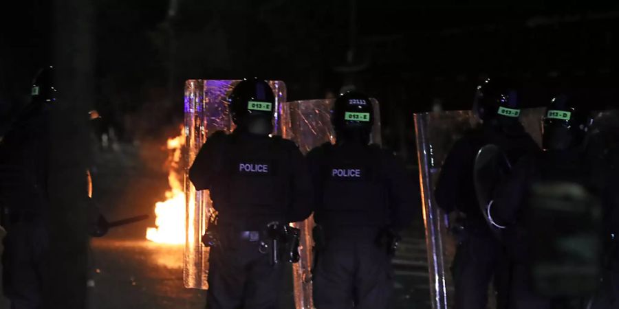 Polizisten mit Schutzschilden stehen in einer Strasse in der Tigers Bay in Belfast während weiterer Unruhen. Foto: Brian Lawless/PA Wire/dpa