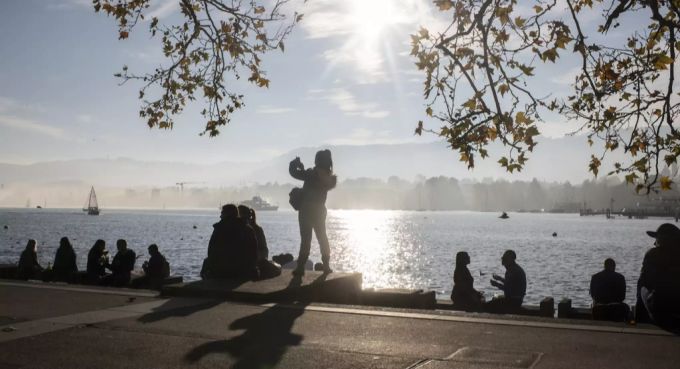 Menschen geniessen die Sonne am Ufer des Zürichsees. Zürichsee Sonne
