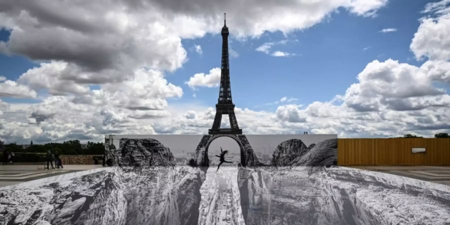 Eine Frau springt über den «Canyon» am Eiffelturm