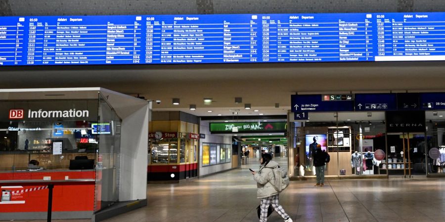 Eine Reisende sucht im Kölner Hauptbahnhof nach einer Möglichkeit, zum Flughafen Düsseldorf zu kommen.