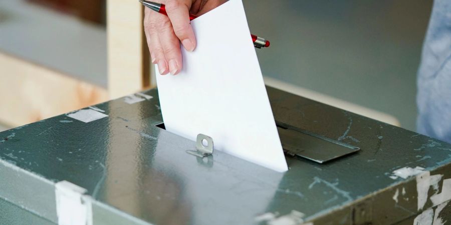Ein Wählerin wirft in einem Wahllokal ihren Stimmzettel in die Wahlurne.