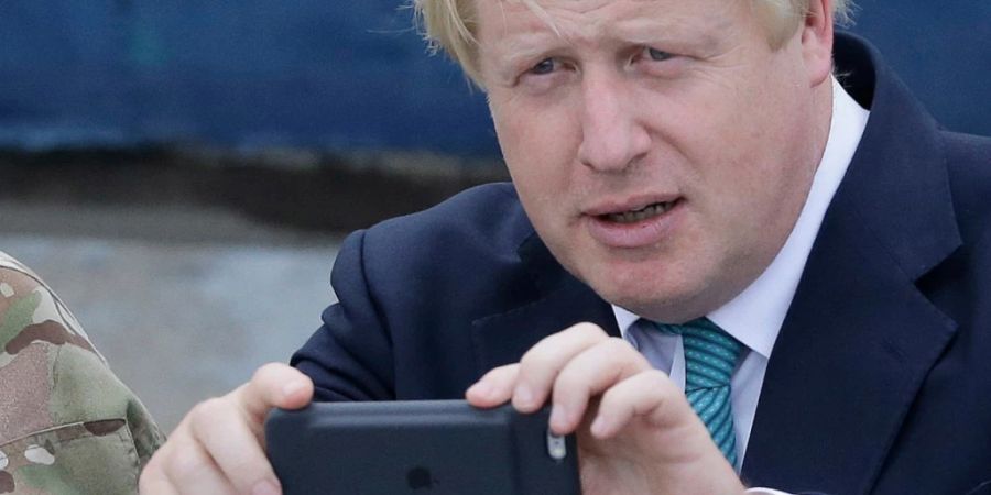 ARCHIV - Boris Johnson, damaliger Aussenminister von Grossbritannien, macht mit seiner Handykamera ein Bild bei einem Besuch in Nigeria. Der britische Ex-Premierminister Boris Johnson sorgt erneut für Schlagzeilen. Medienberichten zufolge soll der 59-Jährige angeblich den Pin-Code für sein altes Handy vergessen haben. Foto: Sunday Alamba/AP/dpa