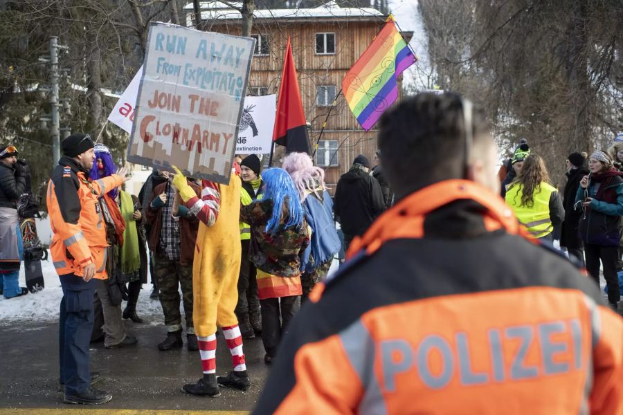 Verkleidete Demonstranten halten Schilder in die Höhe.