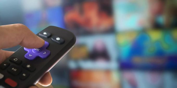 Eine Hand richtet eine Fernbedienung auf den Fernseher. orient-express