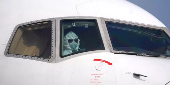Ein Pilot sitzt mit Schutzanzug und Maske im Cockpit und parkt ein Flugzeug . Coronavirus - China