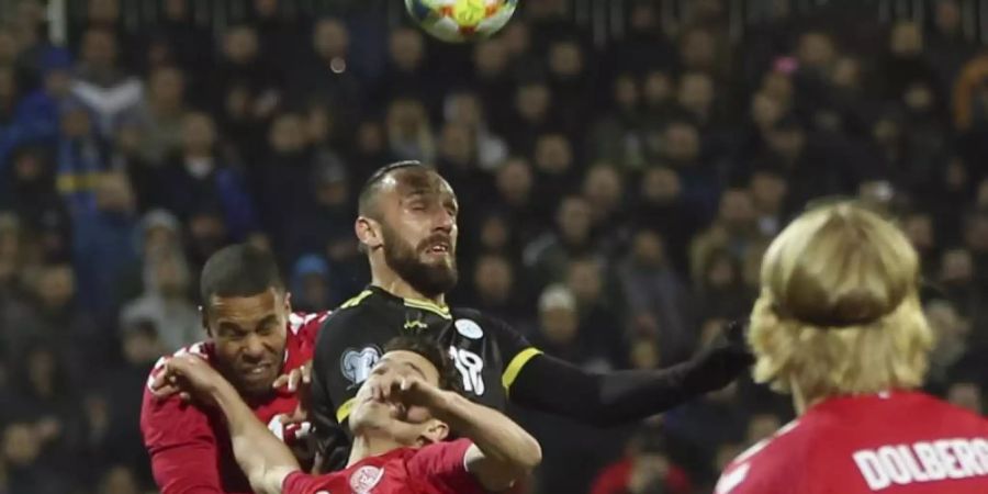 Kosovos Vedat Muriqi (M) sieht sich gleich mehreren Dänen gegenüber. Foto: Visar Kryeziu/AP