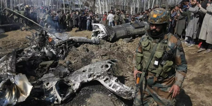 Ein indischer Soldat bewacht die Trümmer des abgeschossenen Kampfflugzeugs im Bezirk Budgam im indischen Teil Kaschmirs. Foto: Mukhtar Khan/AP