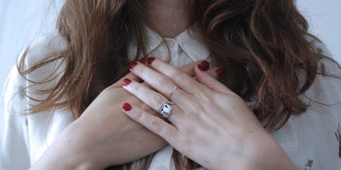 Bei Frauen können auch Atemnot, Übelkeit, Erbrechen, Benommenheit und Schwitzen auf einen Herzinfarkt hindeuten. Hände Nagellack Frau Haare lang Herz Brustkorb