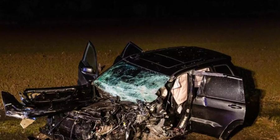 Ein verunfalltes Auto liegt auf einem Feld nahe der B455 zwischen Friedberg und Dorheim. Foto: Wiesbaden112/dpa