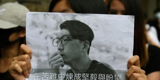 Demonstrant hält Plakat mit Gesicht von Edward Leung Demonstrant hält Plakat mit Gesicht von Edward Leung