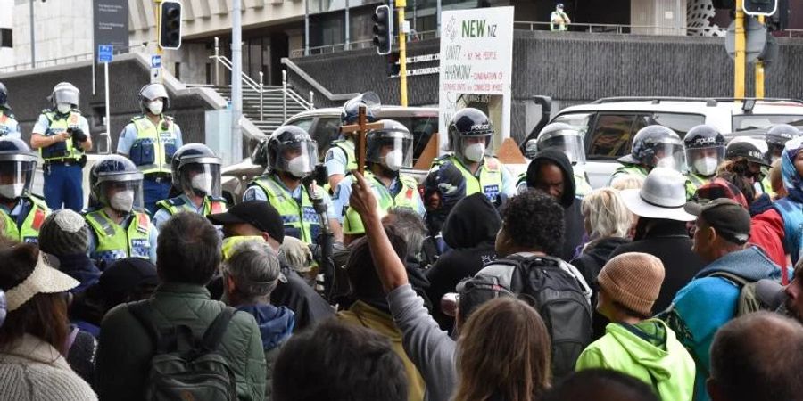 Demonstranten, die gegen das Impfmandat protestieren, stehen vor dem Parlamentsgebäude in Wellington. Foto: Ben Mckay/AAP/dpa