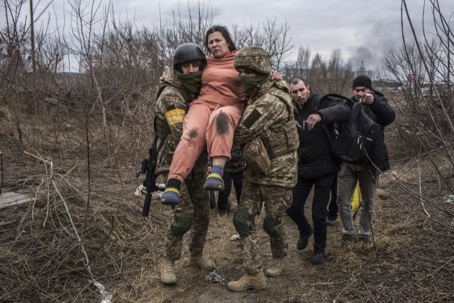 Ukrainische Soldaten helfen Menschen aus Irpin auf der Flucht aus dem Kriegsgebiet.