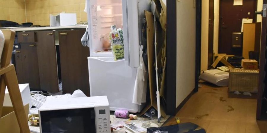 Möbel und Elektrogeräte liegen nach dem Erdbeben verstreut in einer Wohnung in Fukushima. Foto: -/Kyodo News/AP/dpa