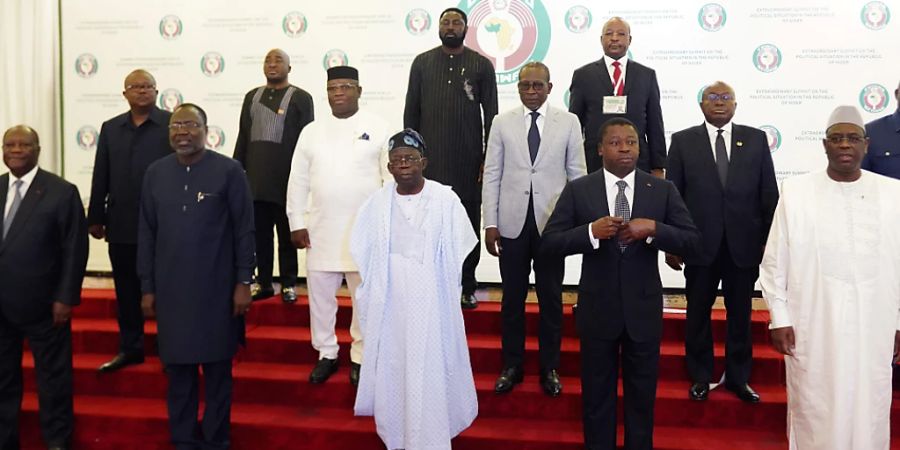 Omar Touray (l), Präsident der Ecowas-Kommission, begrüsst Nana Akufo-Addo (M), Präsident von Ghana, zum Ecowas-Treffen. Zwei Wochen nach der Machtübernahme des Militärs im Niger hat die westafrikanische Staatengemeinschaft Ecowas über das weitere Vorgehen gegen die Putschisten beraten. Foto: Gbemiga Olamikan/AP/dpa