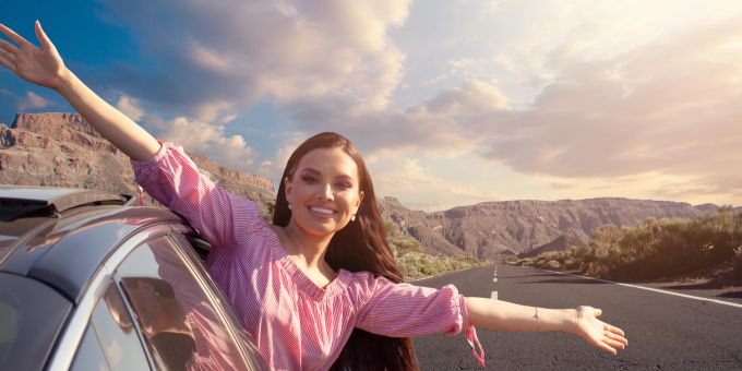 Ein Road Trip macht einfach Spass! Zumindest wenn man weiss, wie man am Benzin spart. Frau im Auto