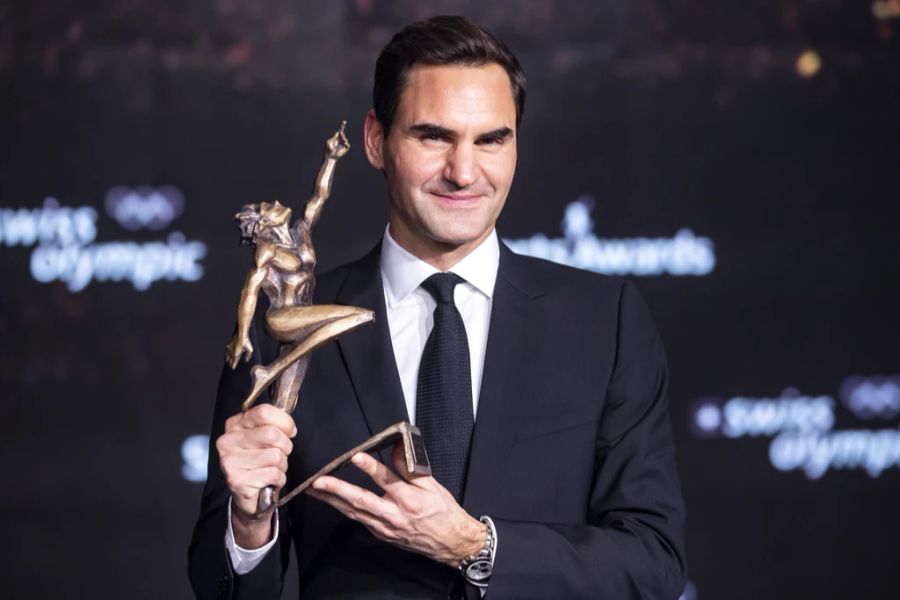 Roger Federer zeigt seinen Ehrenpreis.