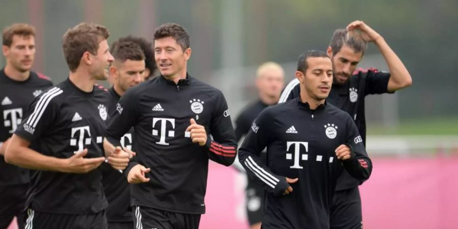 Die Triple-Sieger zurücl auf dem Bayern-Trainingsplatz: Thomas Müller (vorne, l-r), Robert Lewandowski und Thiago. Foto: Tobias Hase/dpa