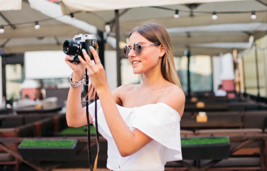 Lächelnde Frau macht Fotos mit Kamera