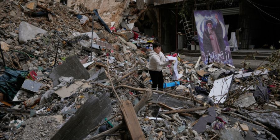 ARCHIV - Ein Junge hält sein Schulbuch, das er in den Trümmern eines zerstörten Gebäudes nach dem Waffenstillstand zwischen der Hisbollah und Israel gefunden hat, in Dahiyeh, einem ...