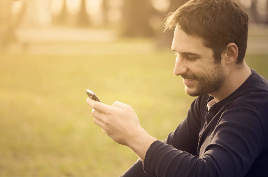 Lächelnder Mann mit Smartphone in der Hand