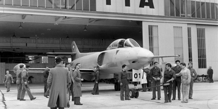 Das neue schweizerische Düsenflugzeug P-16 auf dem Flugplatz Altenrhein SG wird von Pressevertretern und Flughafenpersonal im Juli 1955 begutachtet. (Archivbild)
