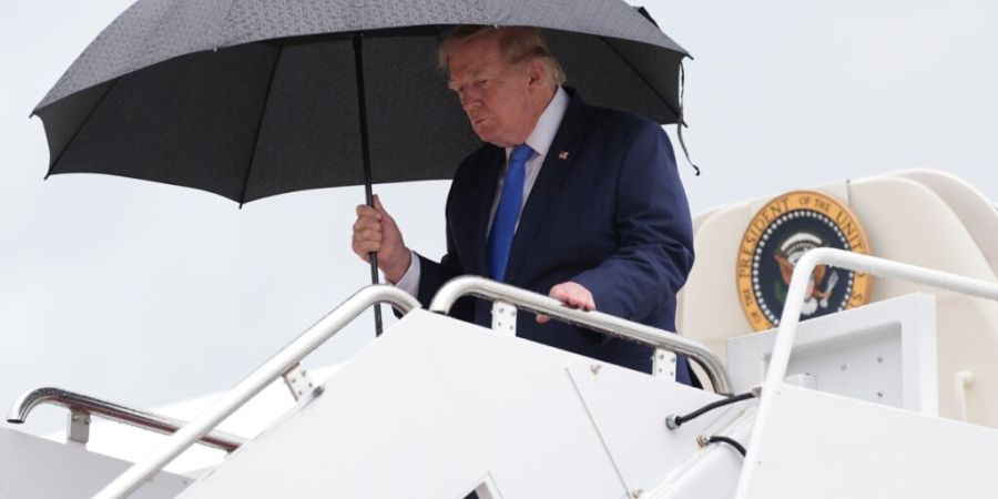 US-Präsident Donald Trump hält einen Regenschirm in der Hand, als er bei seiner Rückkehr nach Washington die Air Force One auf der Joint Base Andrews in Maryland verlässt. Foto: Jac...